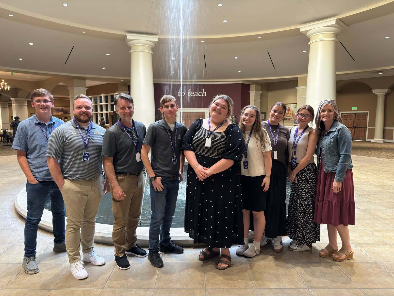 A group from Calvary standing by the fountain in the Crown College lobby during a campus visit