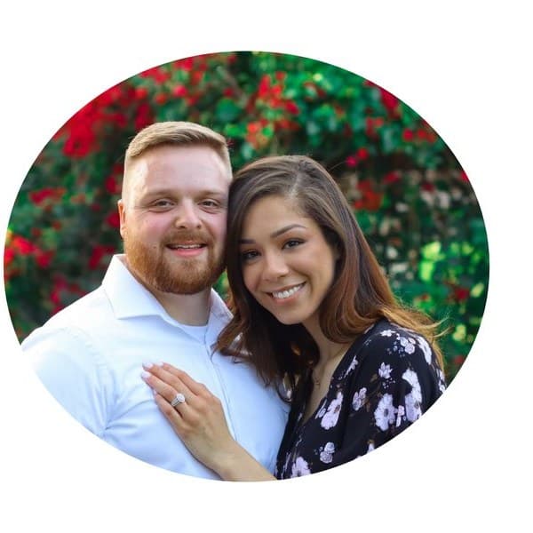 Assistant Pastor Ethan Green and his wife Mitzi outdoors in front of flowering shrubs